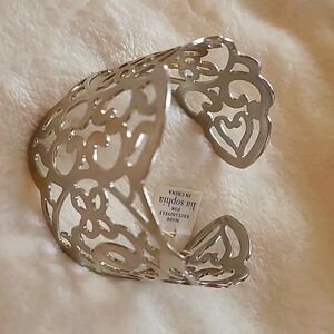 Lia Sophia silver cuff bracelet with intricate cut out designs.
